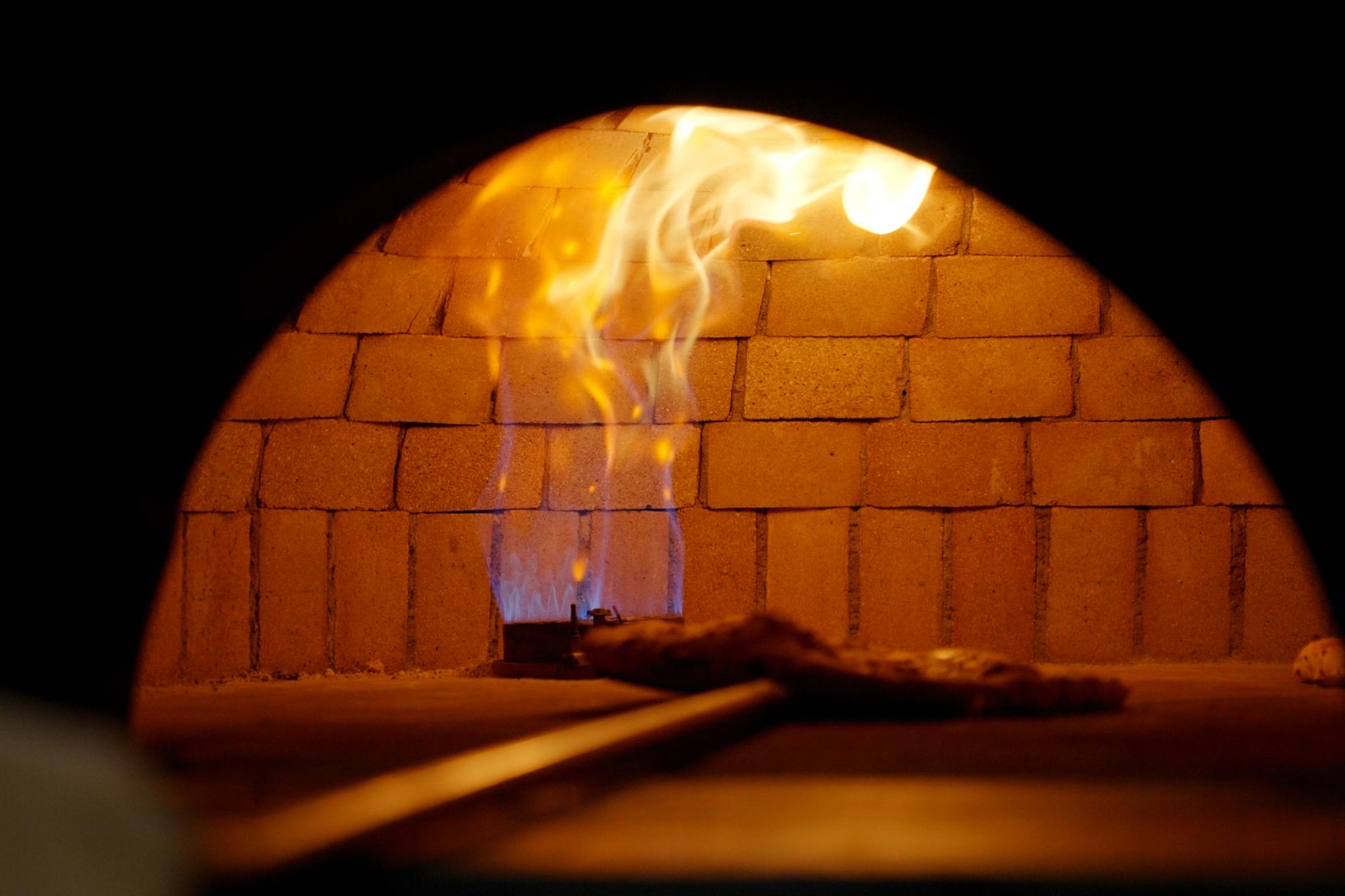 Loderndes Feuer im gemauerten Steinofen